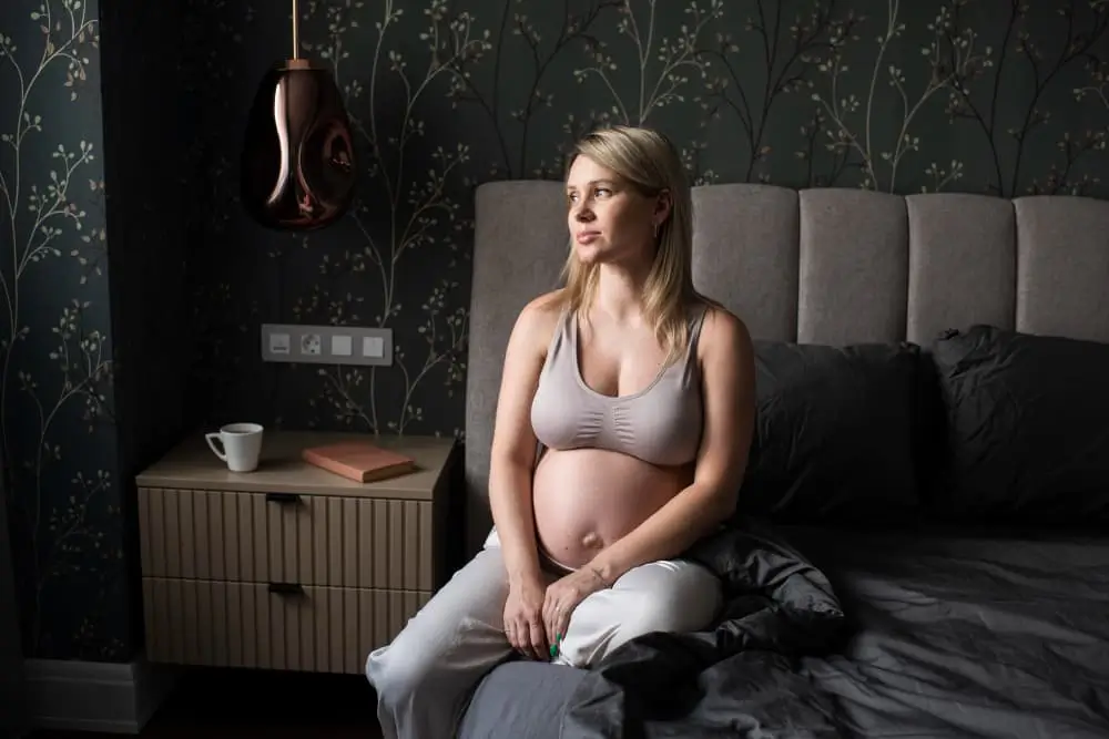 Femme Enceinte De Coup Moyen Sur Le Lit