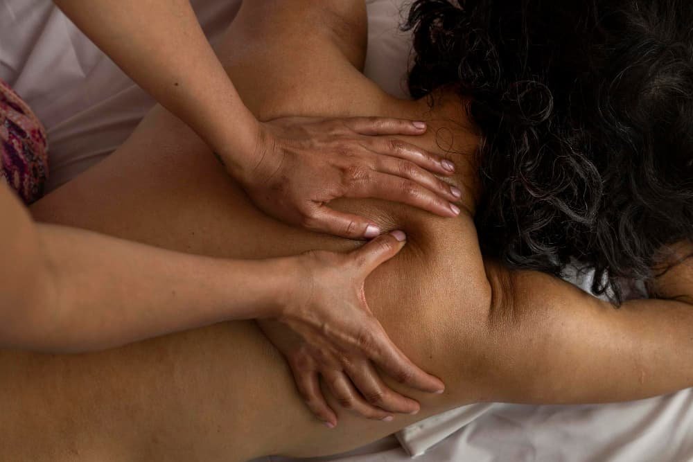Femme allongée sur le dos recevant un massage ayurvédique
