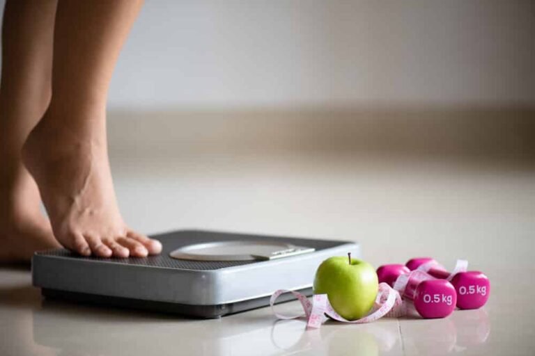 Jambe féminine marche sur une balance
